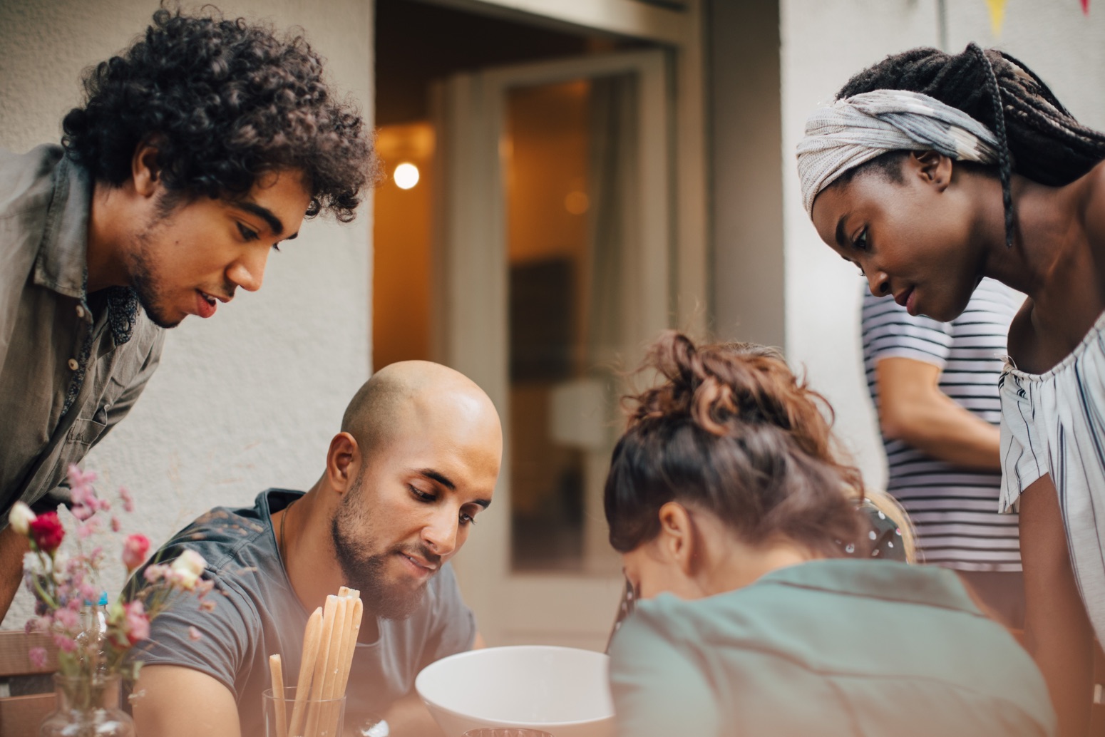 Four students looking at same thing on table