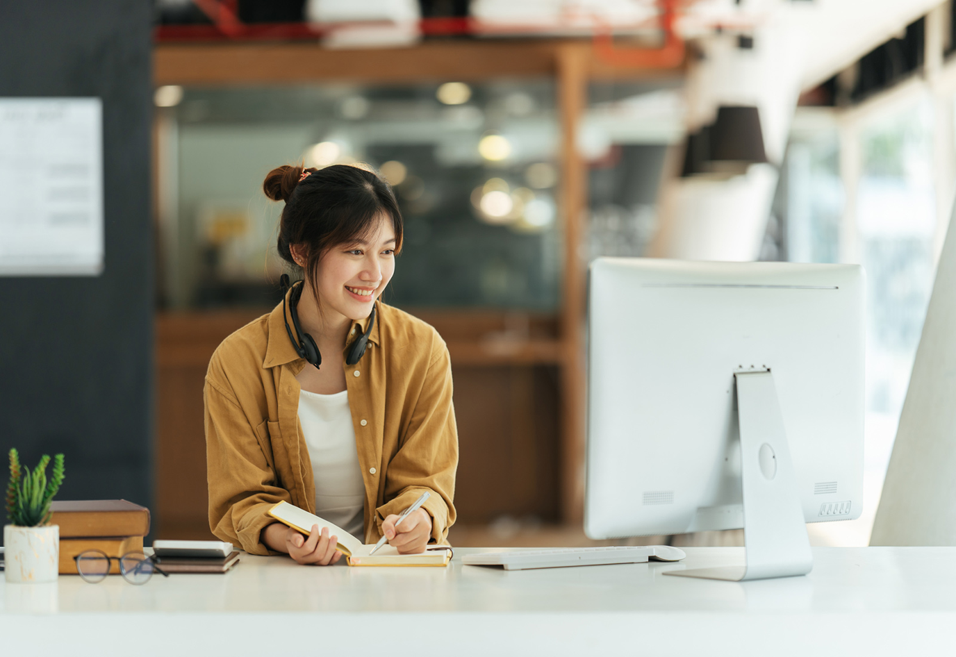 library staff at desktop computer with book
